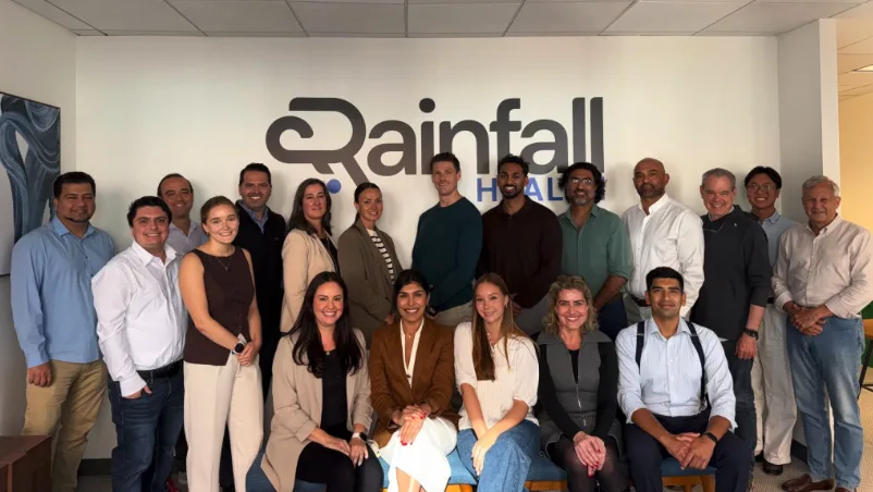 The Rainfall Health team in front of the company logo